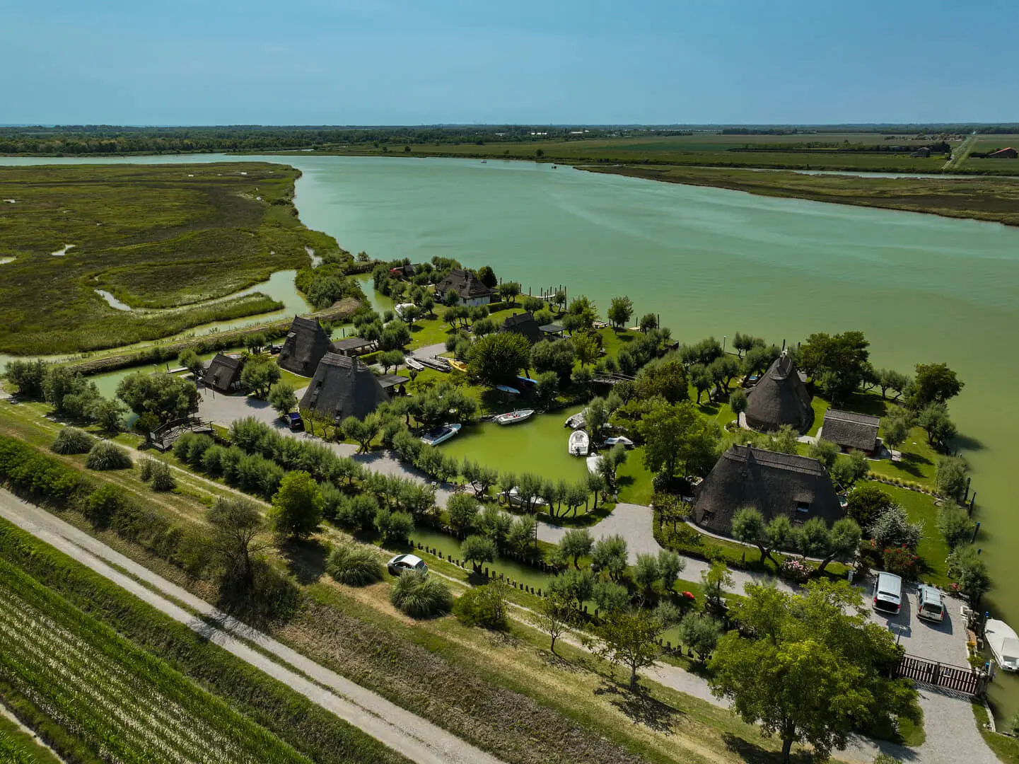 Villaggio rurale con case e fiume verde accanto.